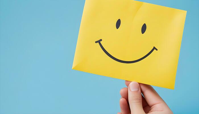 ai-generated-a-happy-hand-holding-a-yellow-smiley-face-paper-free-photo